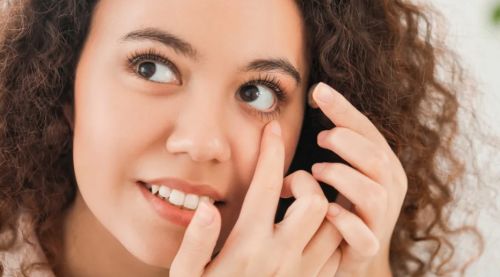 A woman putting contact lenses.