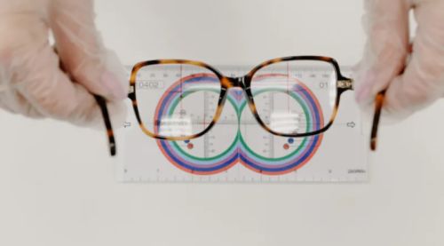 Ophthalmologist measuring eyeglasses with a lens ruler.