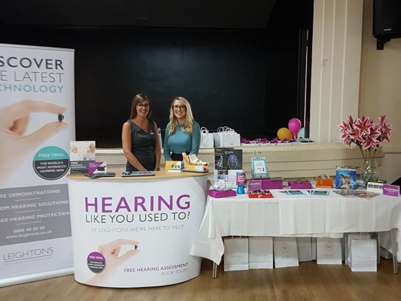 Two women at Open Sight fair stand