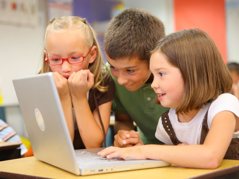 Children gathered round laptop