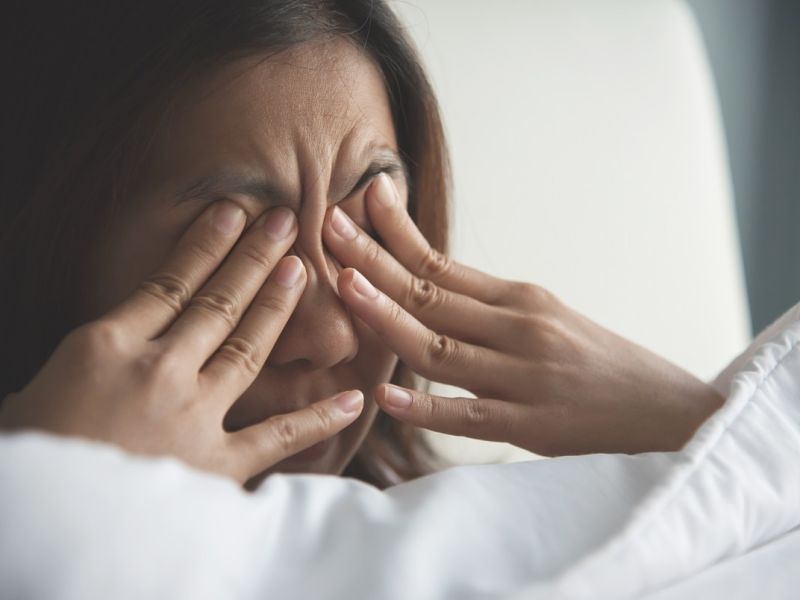 Woman rubbing eyes with fingers