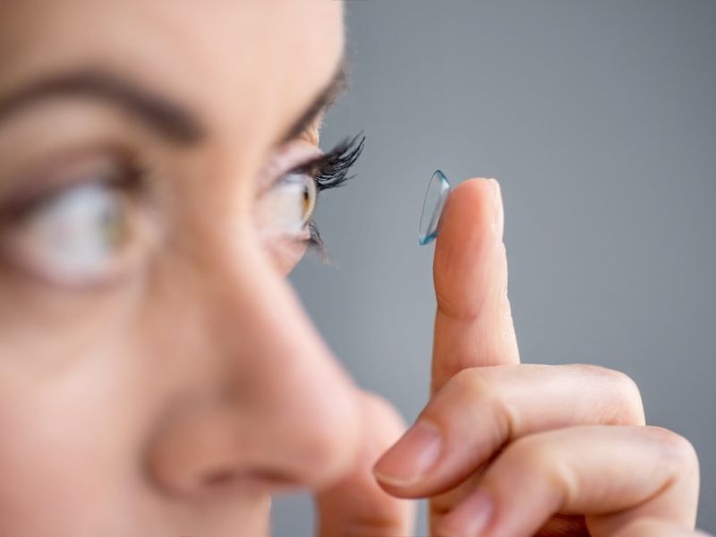 Woman putting contact lens in eye