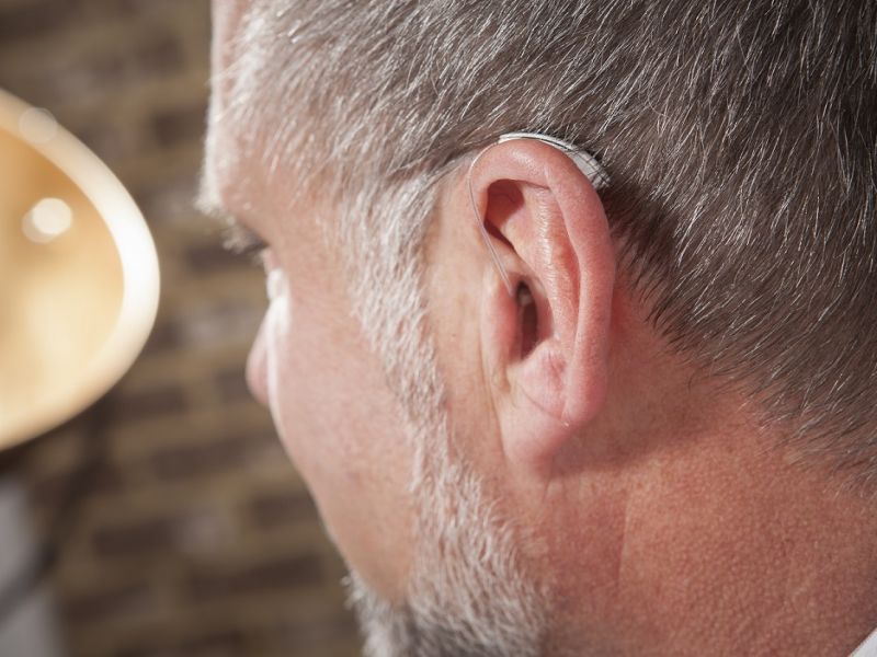 Close up of hearing aid in mans ear