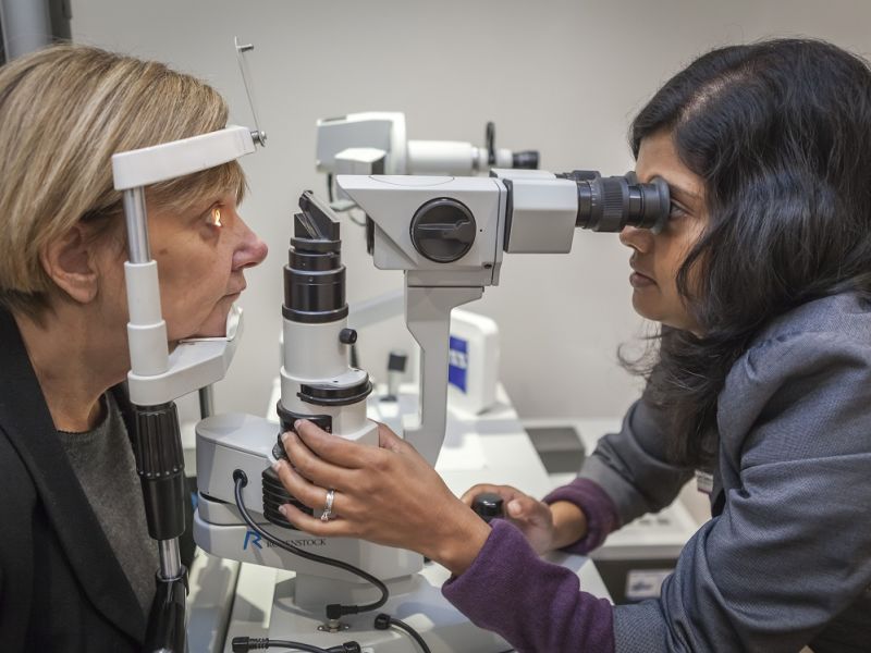 Optometrist performing eye test on woman