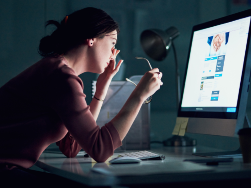 Shot of a young businesswoman using a computer during a late night at work and looking tired