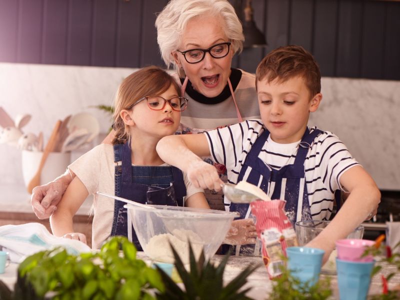 Woman and two children baking