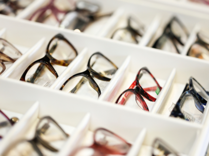Display featuring a variety of glasses in different colors, showcasing diverse styles and designs.