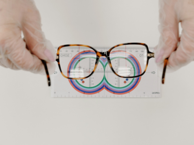 Ophthalmologist measuring eyeglasses with a lens ruler.