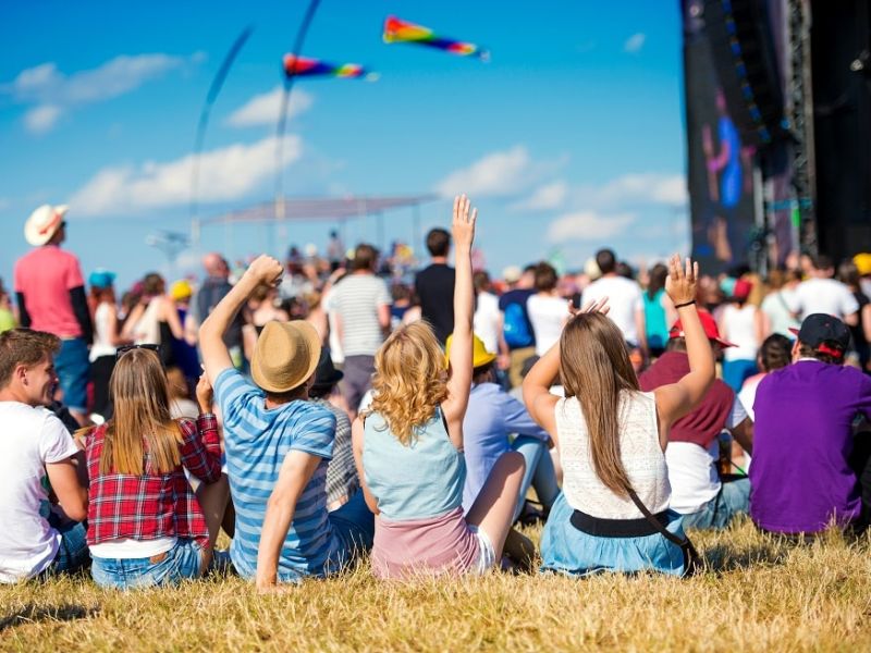 Young people sat facing stage at a festival