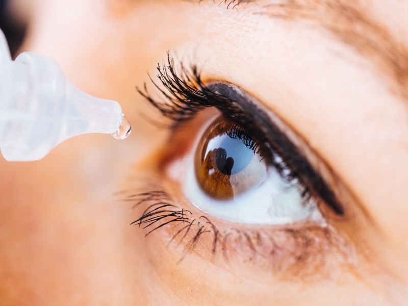 Woman inserting eye drop