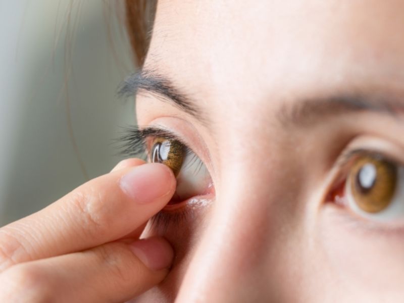 Close-up shot of a young woman gently removing her contact lenses.