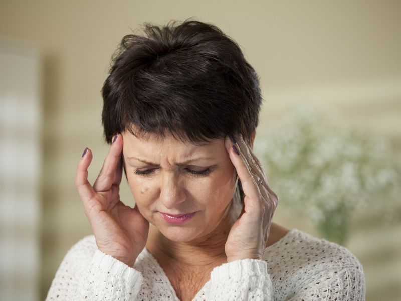 Woman with migraine holding temples