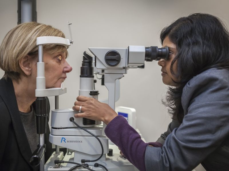 Optometrist performing eye test on woman