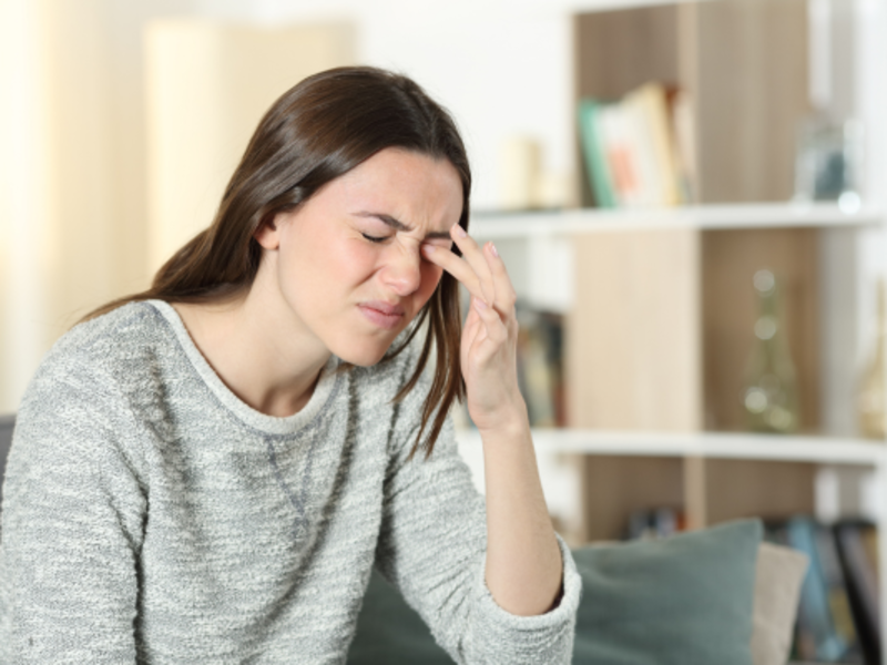 Woman scratching itchy and painful eye at home.