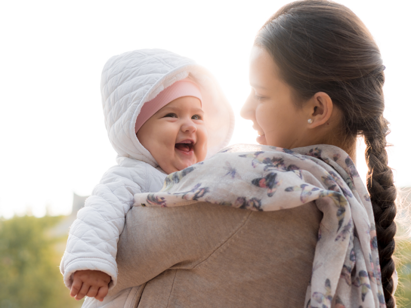 A mother with her baby in her arms.