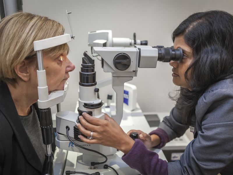 Optometrist performing eye test on woman