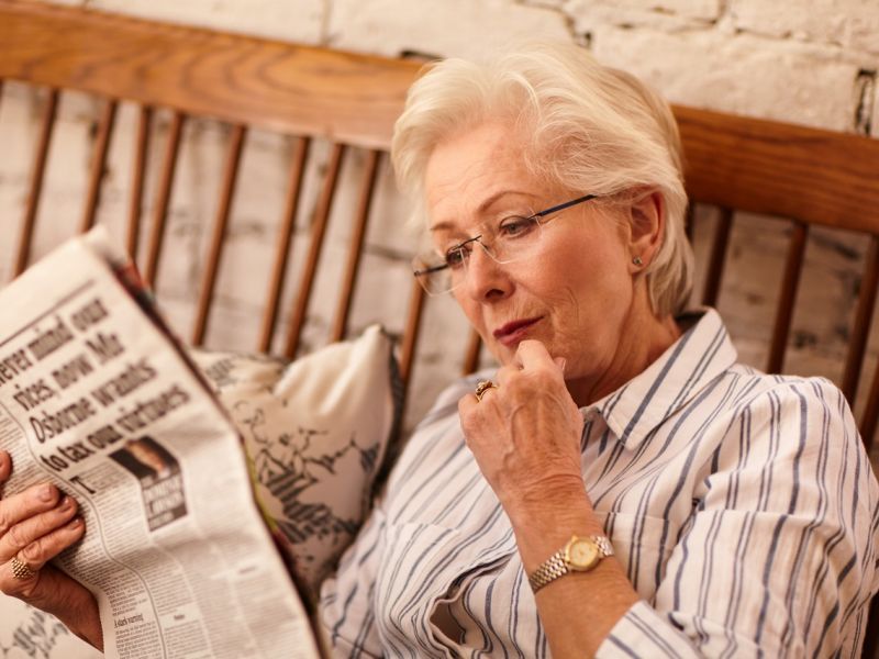 Woman sat down reading newspaper