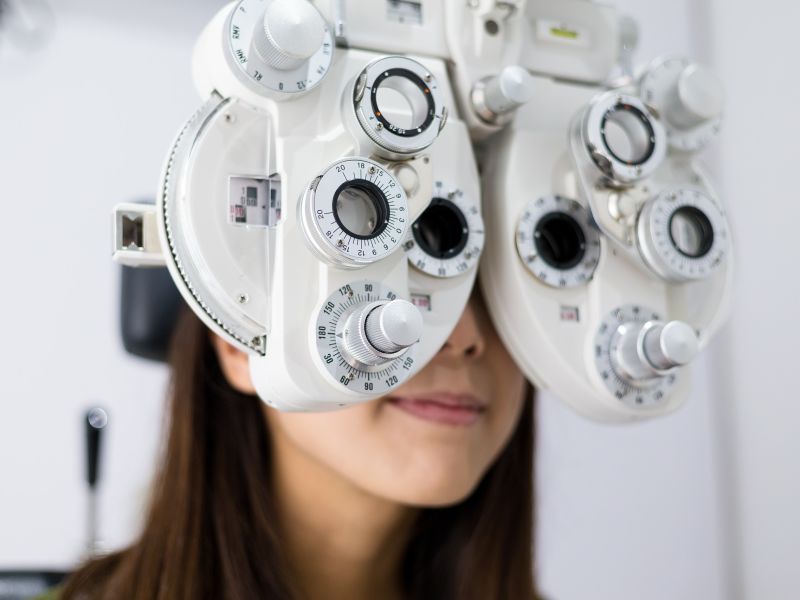 Woman having Leightons eye test with phoropter head technology