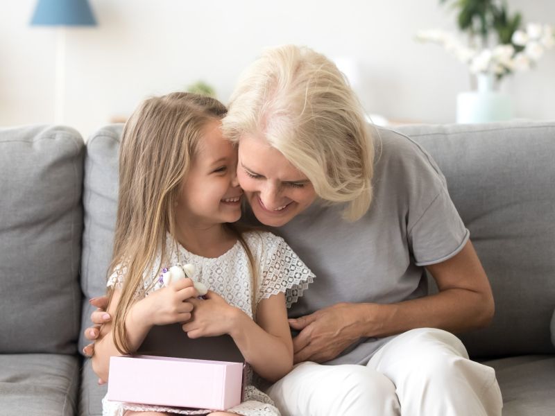 girl whispering to joke to grandmother