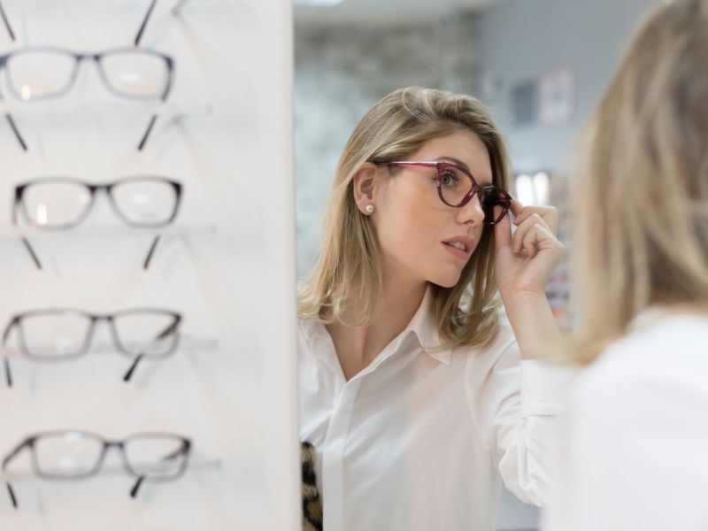 Woman in mirror choosing sunglasses