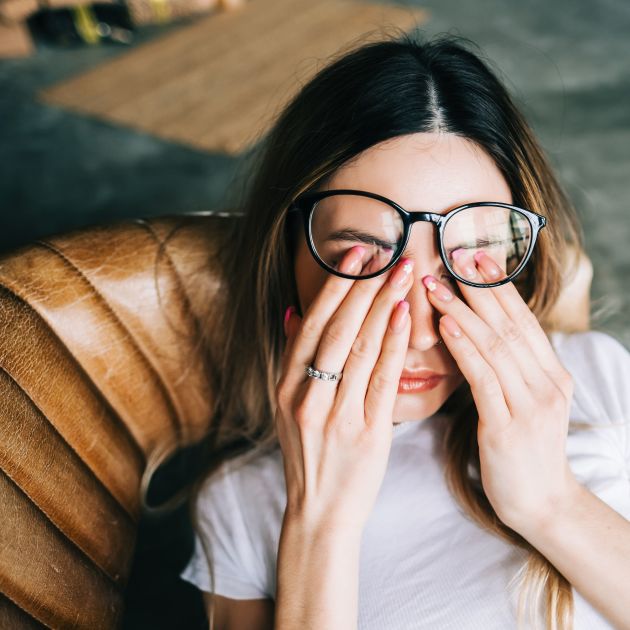 Young woman rubs her eyes.