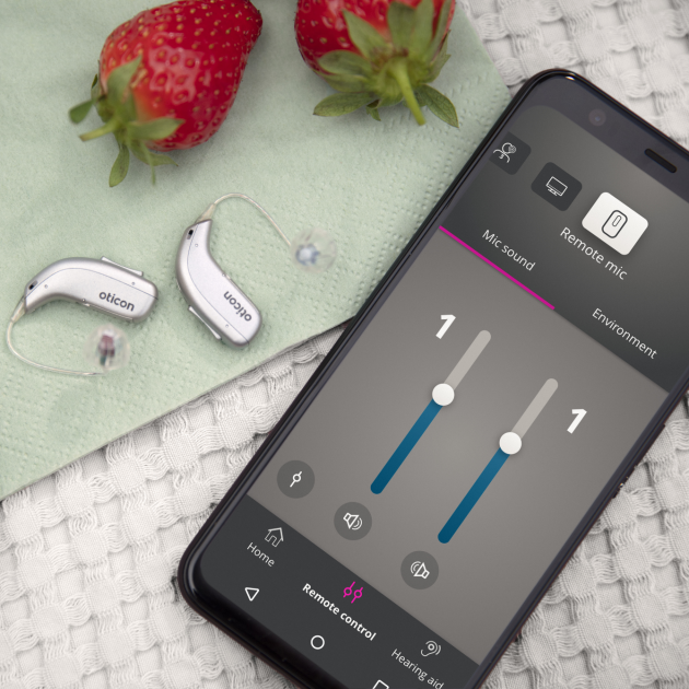 Oticon More™ in a sophisticated living situation near strawberries