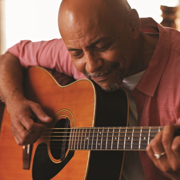 man tuning guitar