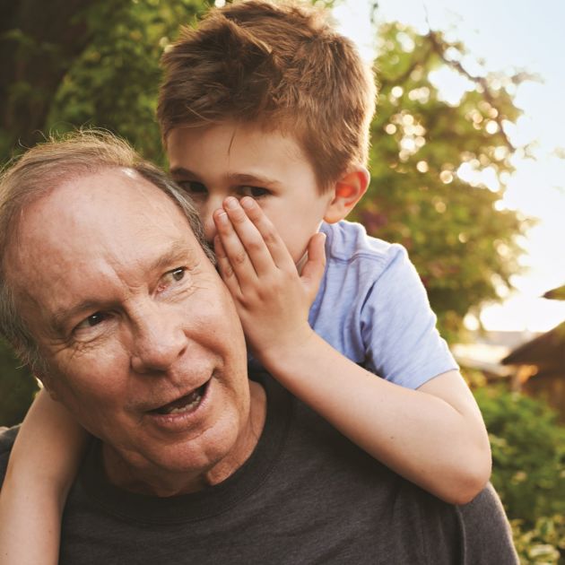 child whispering to grandfather