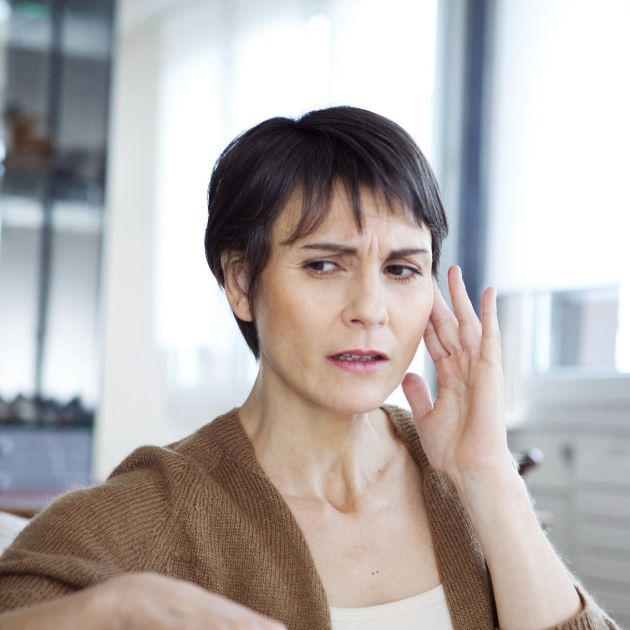 woman holding her ear, concerned about her hearing