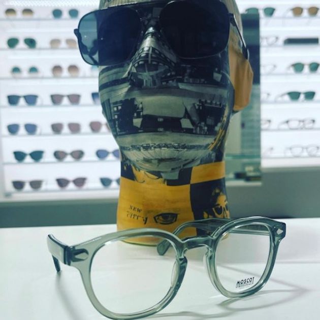 Clear MOSCOT frame in front of mannequin head wearing MOSCOT sunglasses