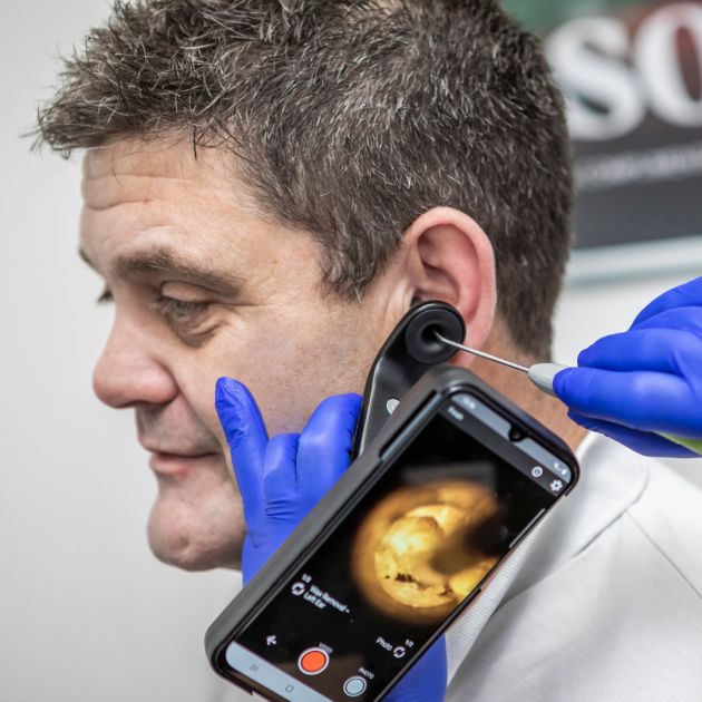 An audiologist performing microsuction on a patient.