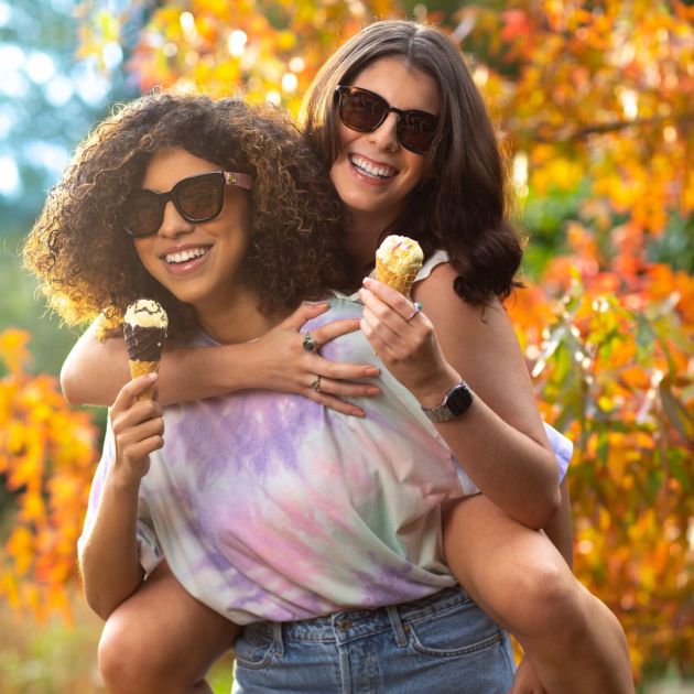 two female models in sunglasses with ice creams in hand.