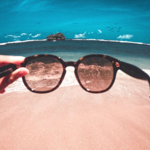 image looing through a pair of sunglasses on the beach