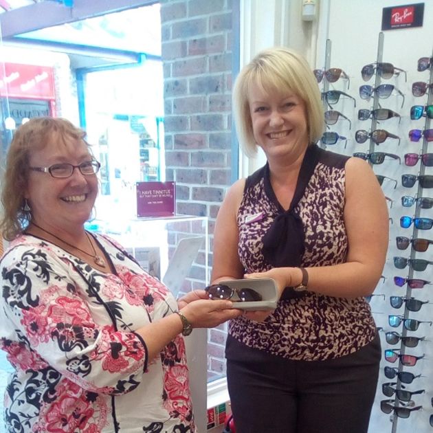 One of the charity raffle winners receiving their prize: a pair of sunglasses.