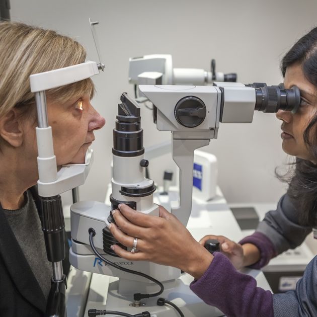 An optometrist examining the eye of a patient with cataracts.