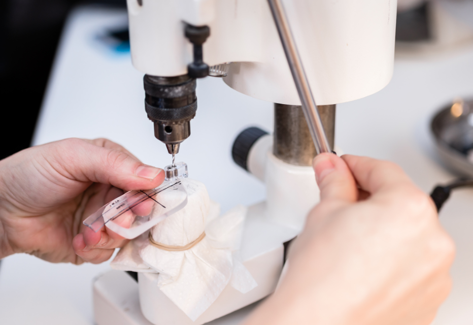Man polishing spectacle glasses in an optical workshop, demonstrating the process of lens finishing.
