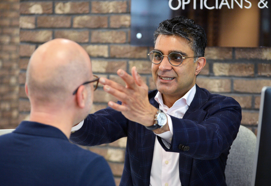 A dispensing optician fitting glasses on a patient, ensuring a proper fit and comfort.