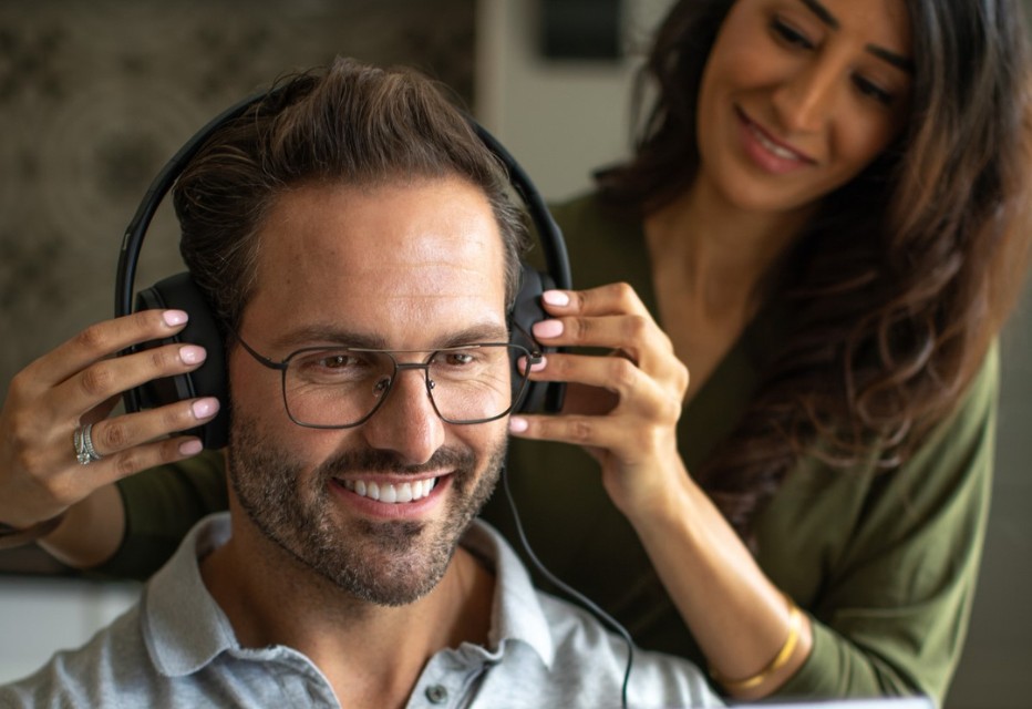 Audiologist placing headphones on a patient's head in preparation for a hearing test.