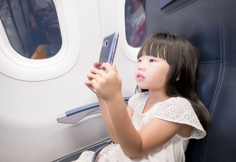 A young girl holding a smartphone close to her eyes, showing concern for her eye health.