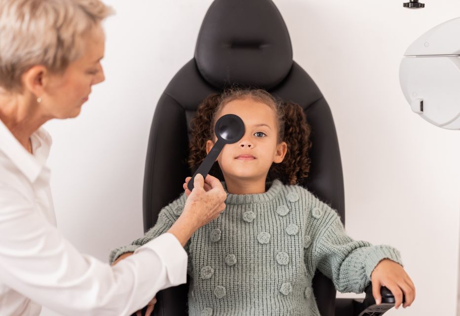 Girl getting a vision test with a occluder.