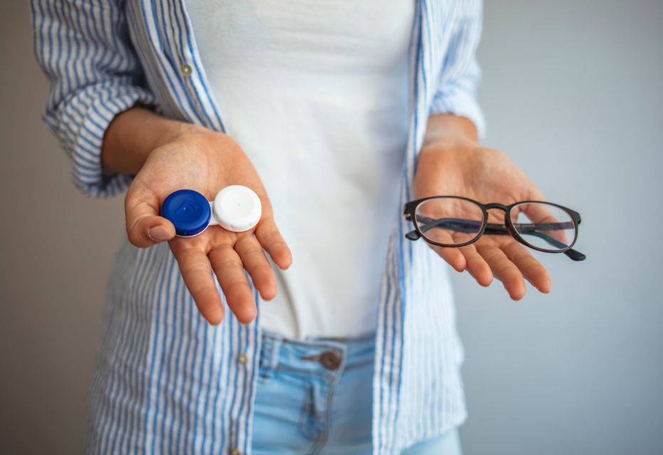 Woman hold contact lenses and glasses in hands close up.