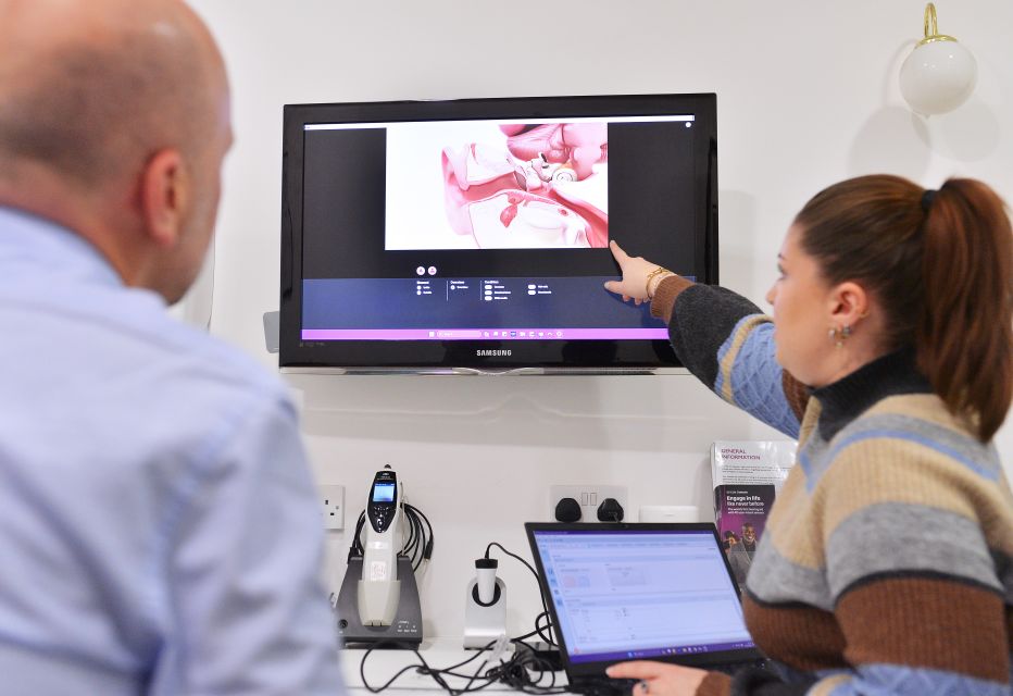 An audiologist explaining the result of a patient hearing test.