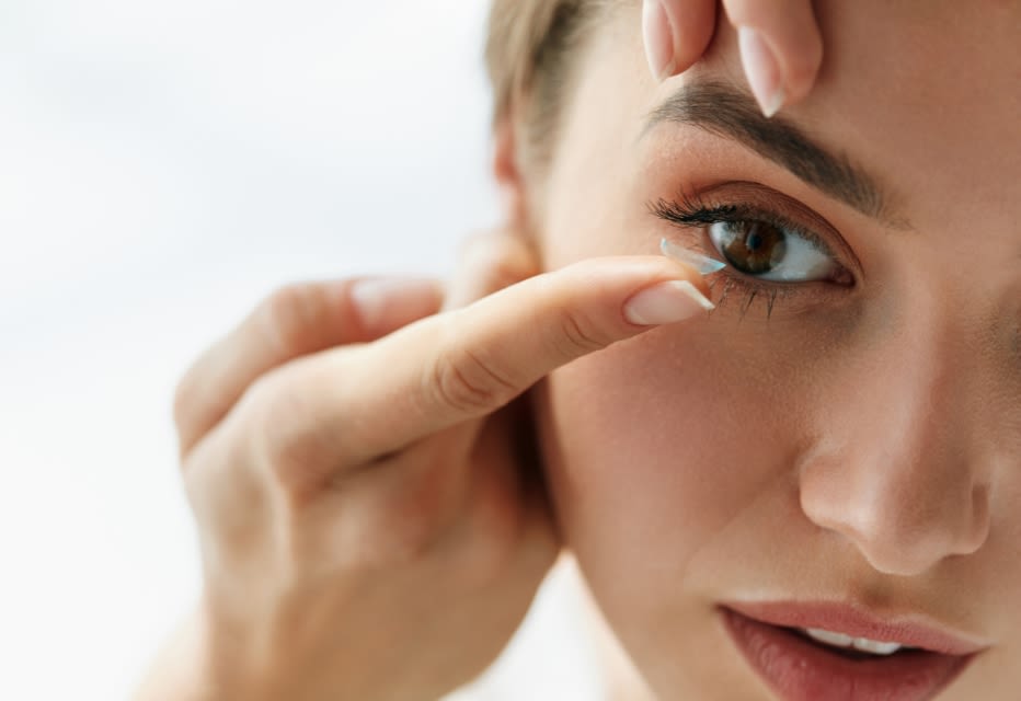 A woman inserting a contact lens.
