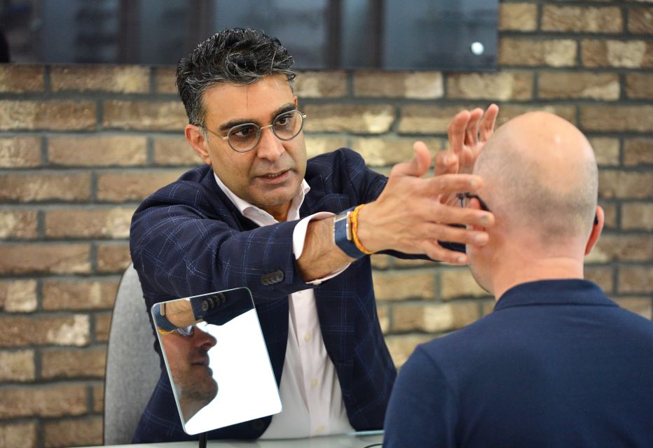 A dispensing optician helping a patient find glasses frames.