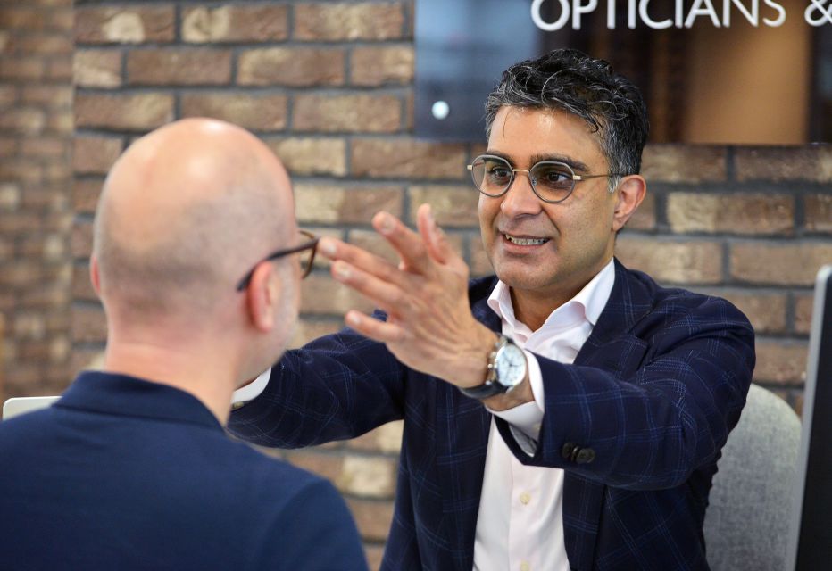 A dispensing optician fitting glasses on a patient, ensuring a proper fit and comfort.