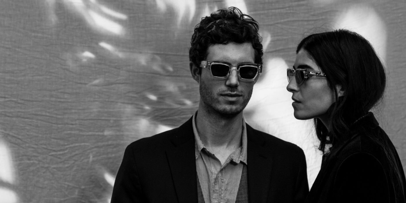 A black and white photo of a man and woman wearing AHLEM sunglasses.