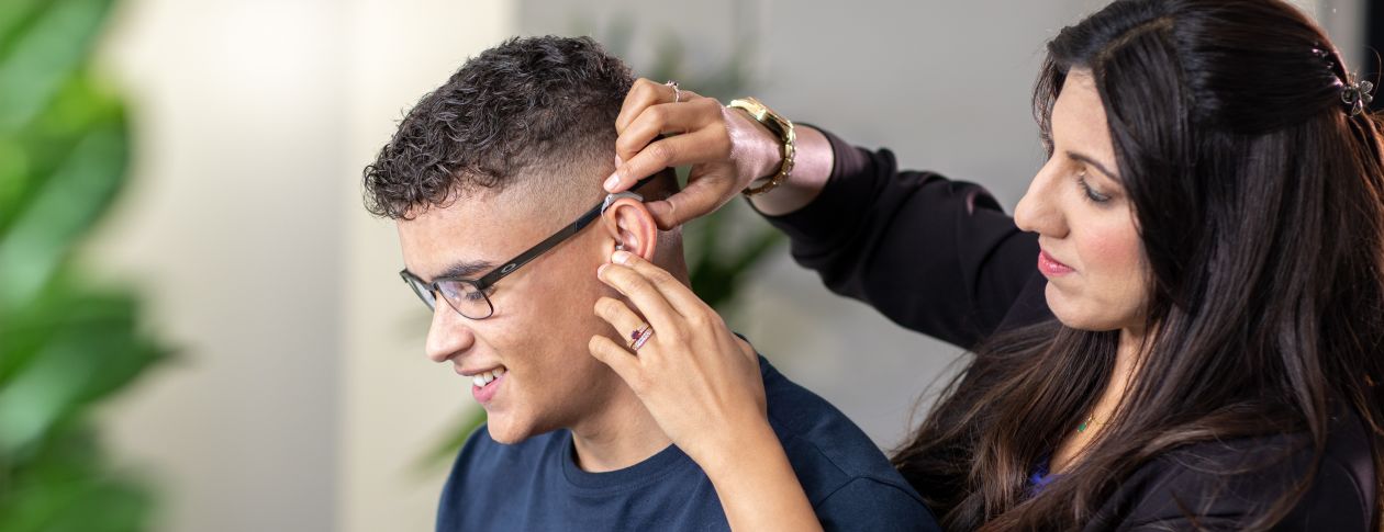 Audiologist Salma fitting a hearing aid