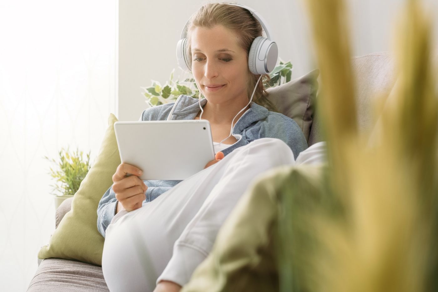 Woman wearing headphones listening to tablet