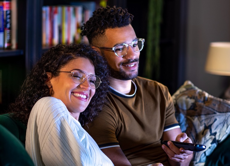 man and woman sat on sofa