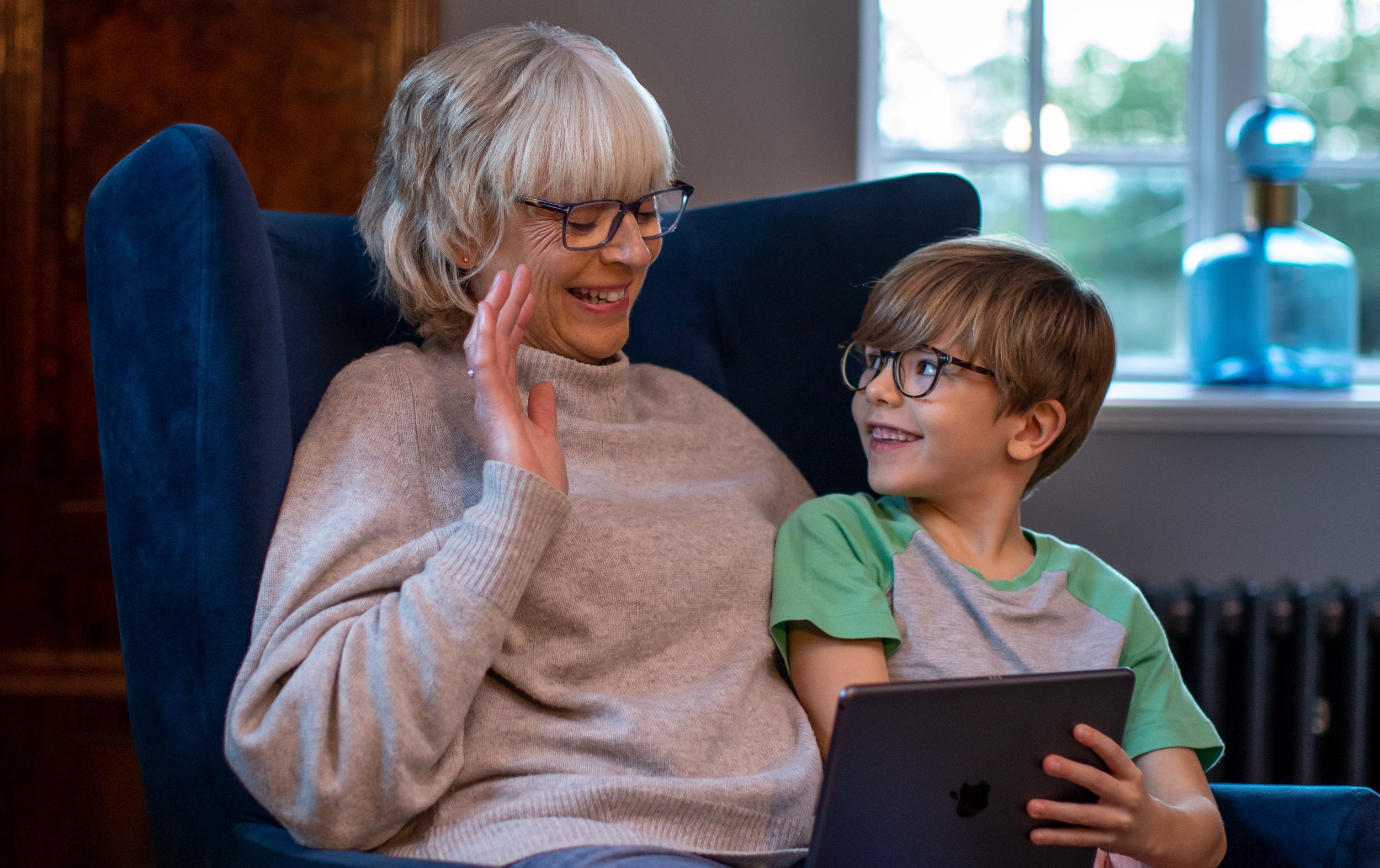 grandmother and child looking at tablet screen